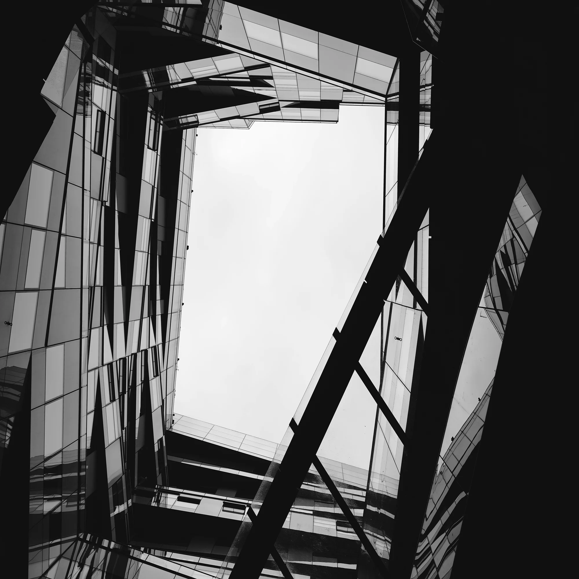Kontrastreiche Low-Angle-Aufnahme moderner Architektur mit komplexen Reflexionen und scharfen Linien.